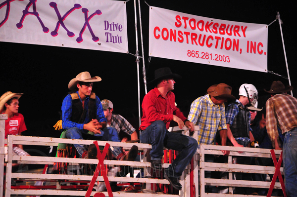 Cowboys sit atop a fence during the Red Gate Rodeo in Maynardville, Tennessee